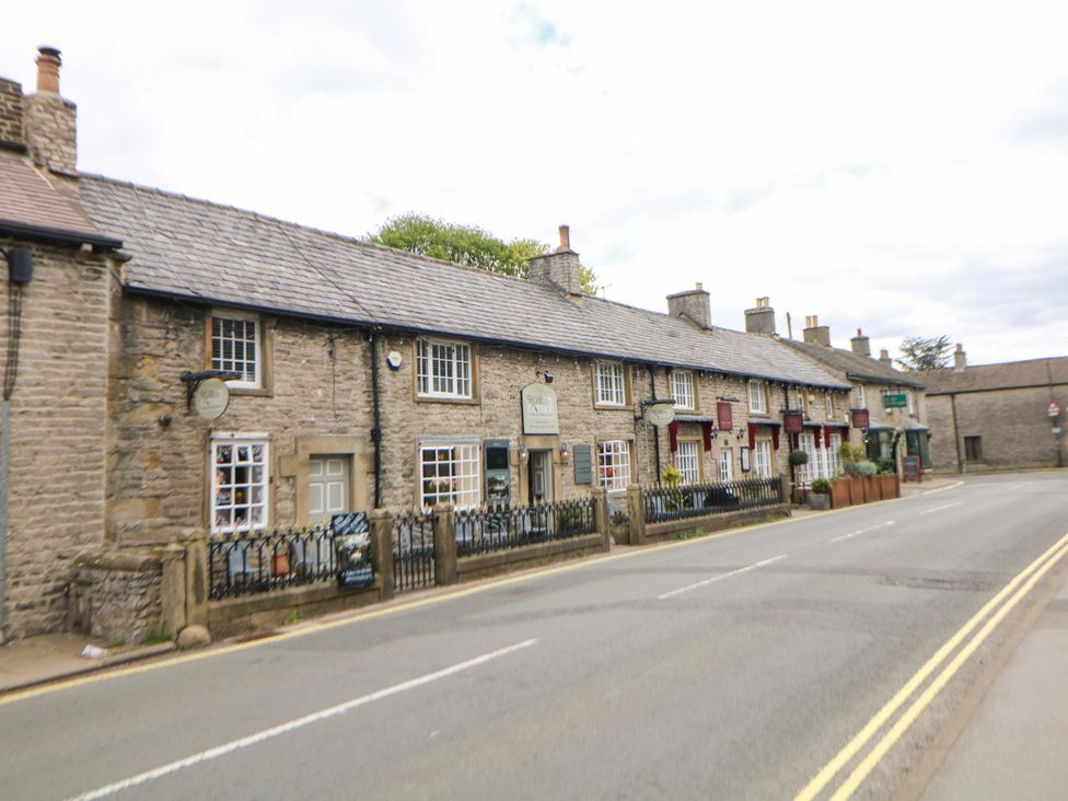 A row of stone houses with a fence along the road at Bargate Cottage Hope Valley