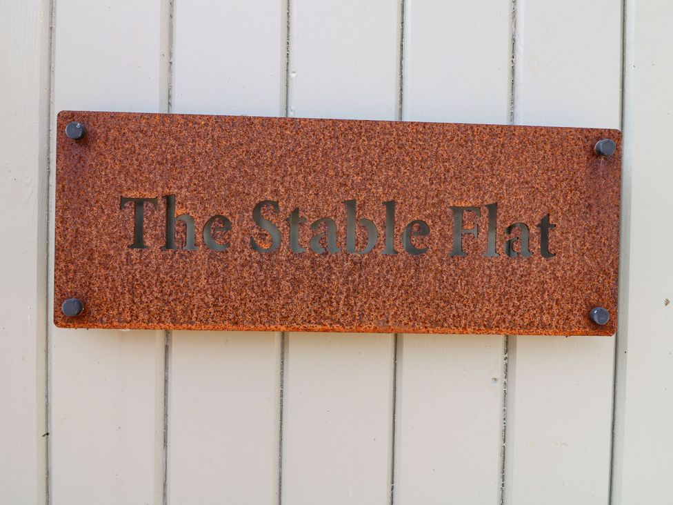 A nameplate displaying The Stable Flat at The Stable Flat