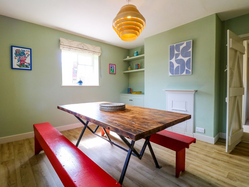 A dining room with a table and benches at The Stable Flat
