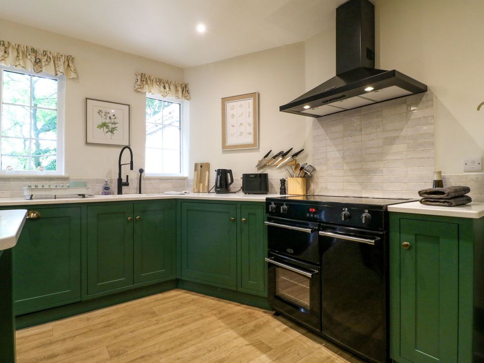 A kitchen with cabinets and an oven at The Stable Flat in 
