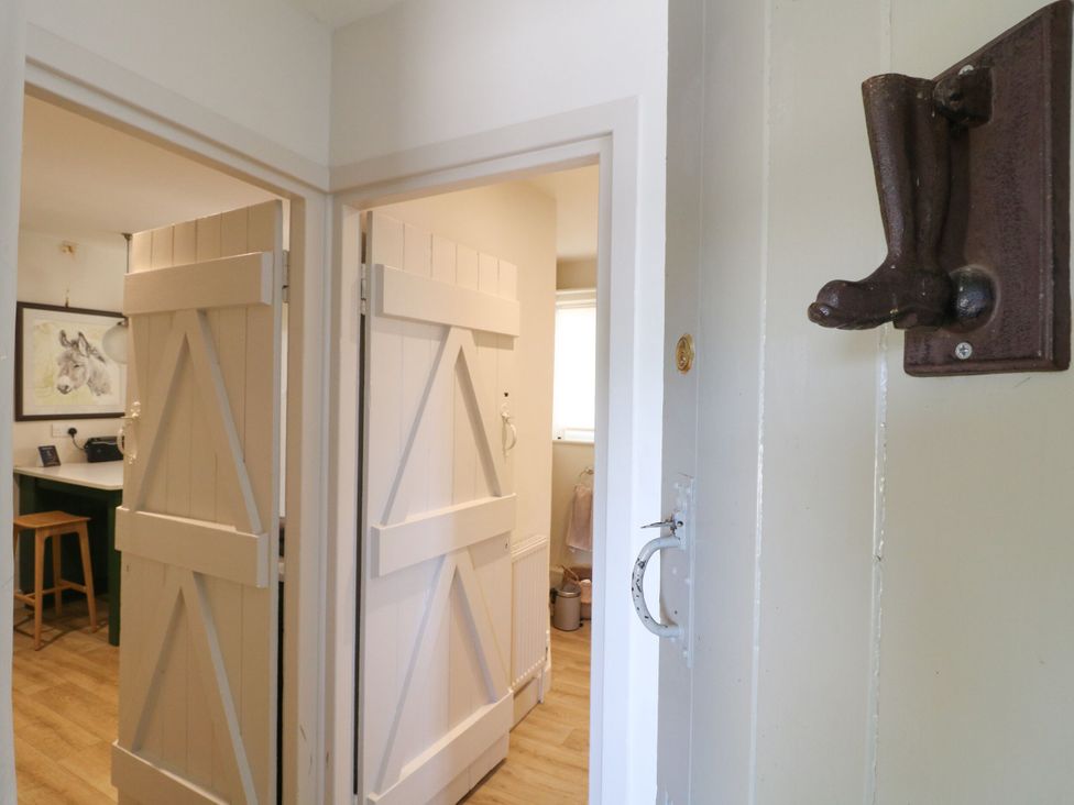A hallway with doors and a wall hook at The Stable Flat