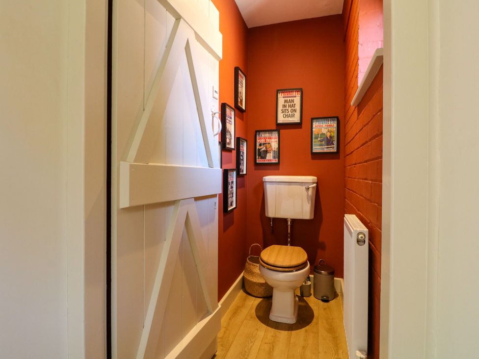 A bathroom with a toilet and wall art at The Stable Flat