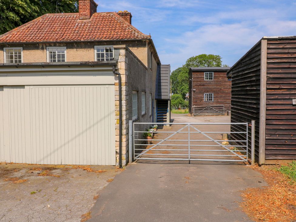An outdoor area with a house, garage, and gate at The Stable Flat in 