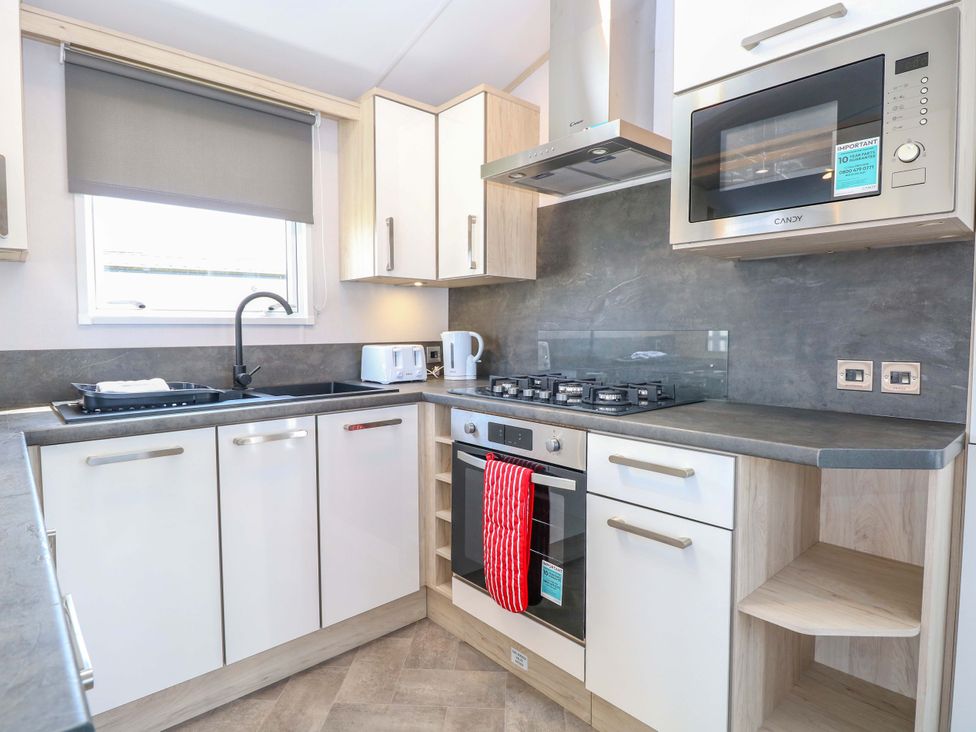 A kitchen with cabinets and appliances at Sandy Shores Retreat in Norwich