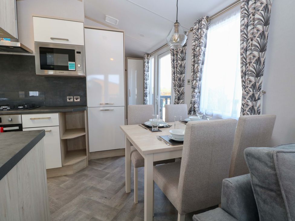 A kitchen with dining area featuring a table and chairs at Sandy Shores Retreat in Norwich