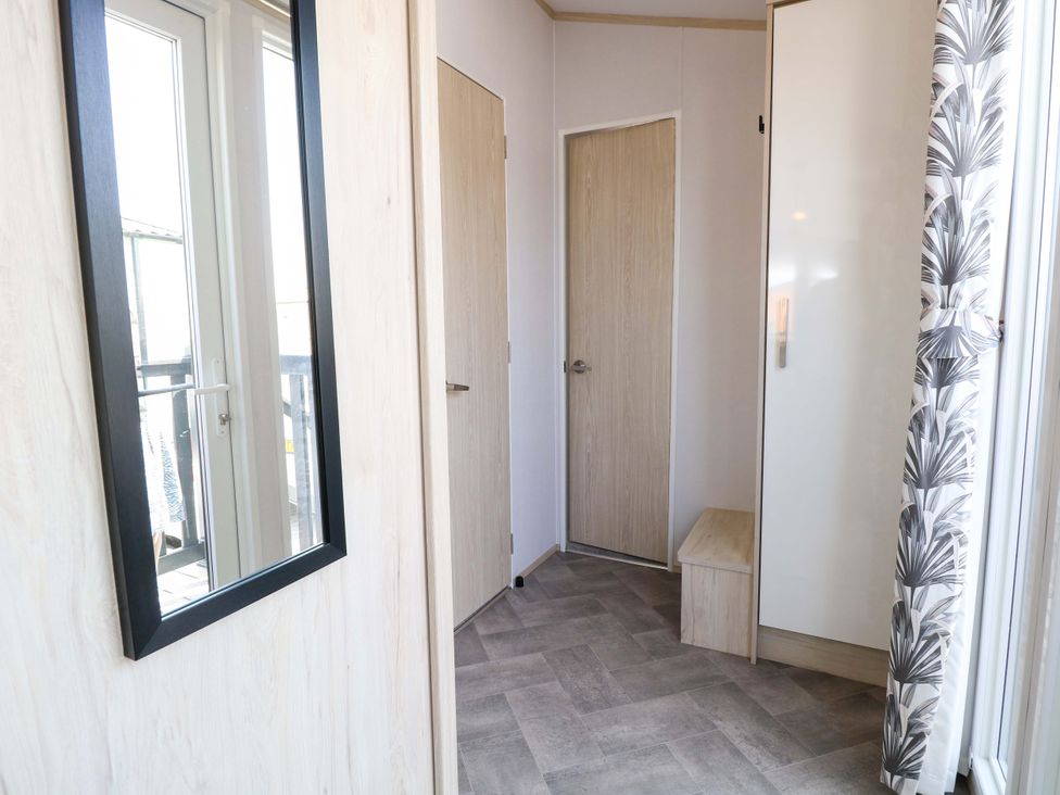 An entryway with a mirror and doors at Sandy Shores Retreat in Norwich
