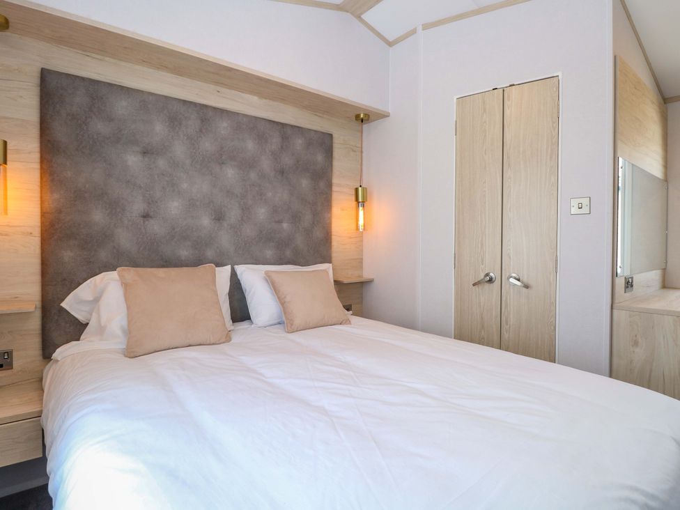 A bedroom with a bed and a cupboard at Sandy Shores Retreat in Norwich