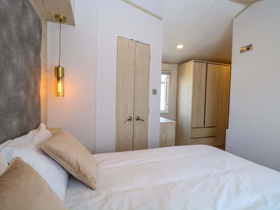A bedroom with a bed and wardrobe at Sandy Shores Retreat in Norwich