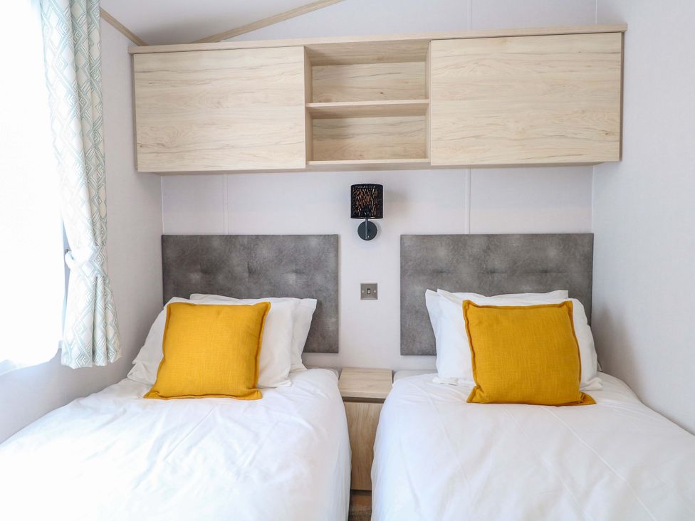 A bedroom with two beds and a shelf at Sandy Shores Retreat in Norwich