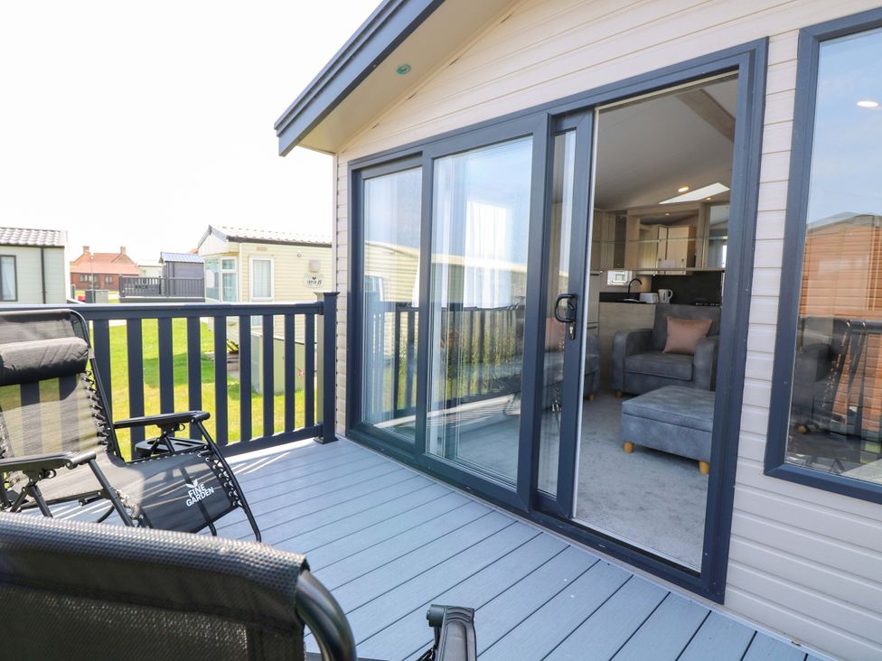 A deck with chairs and a sliding door at Sandy Shores Retreat in Norwich
