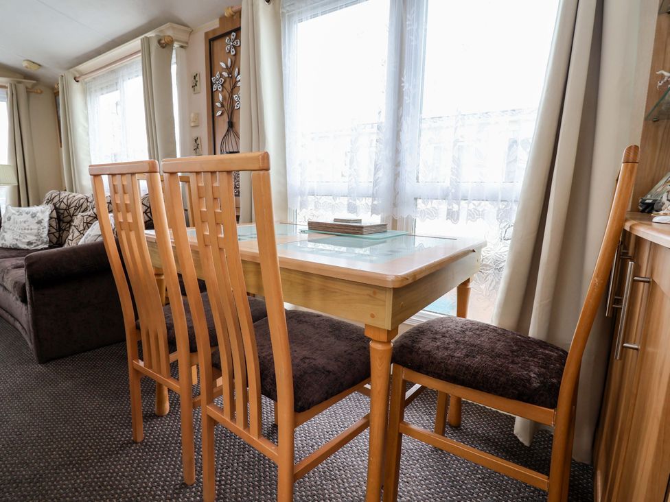 A dining room with a table and chairs at Winchester - 478 in Abergele