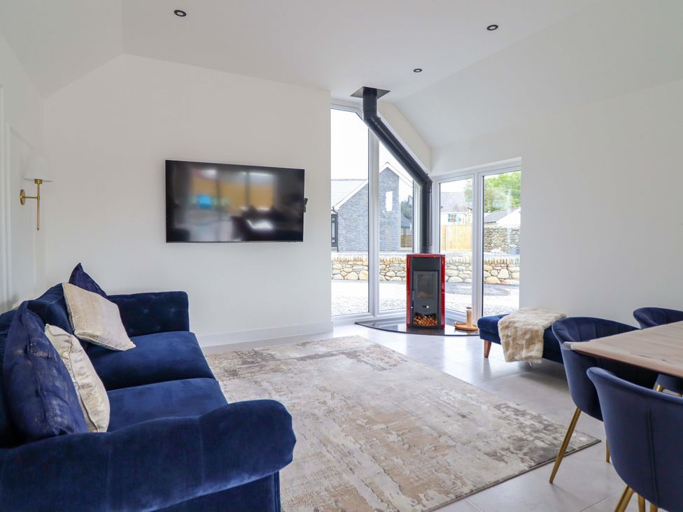 A living room with a television and fireplace at Kingfisher