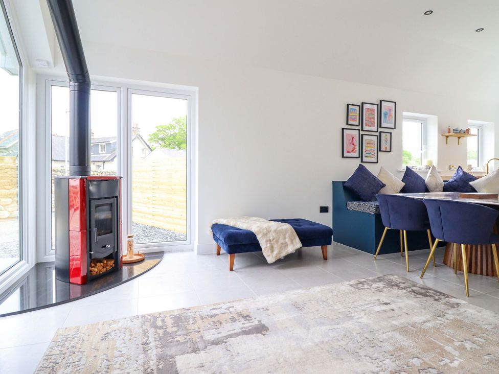 A living room with a stove and dining area at Kingfisher