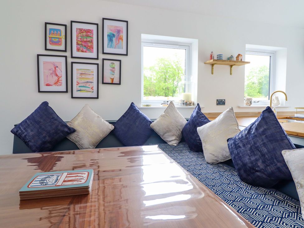 A dining room with cushions and artwork at Kingfisher