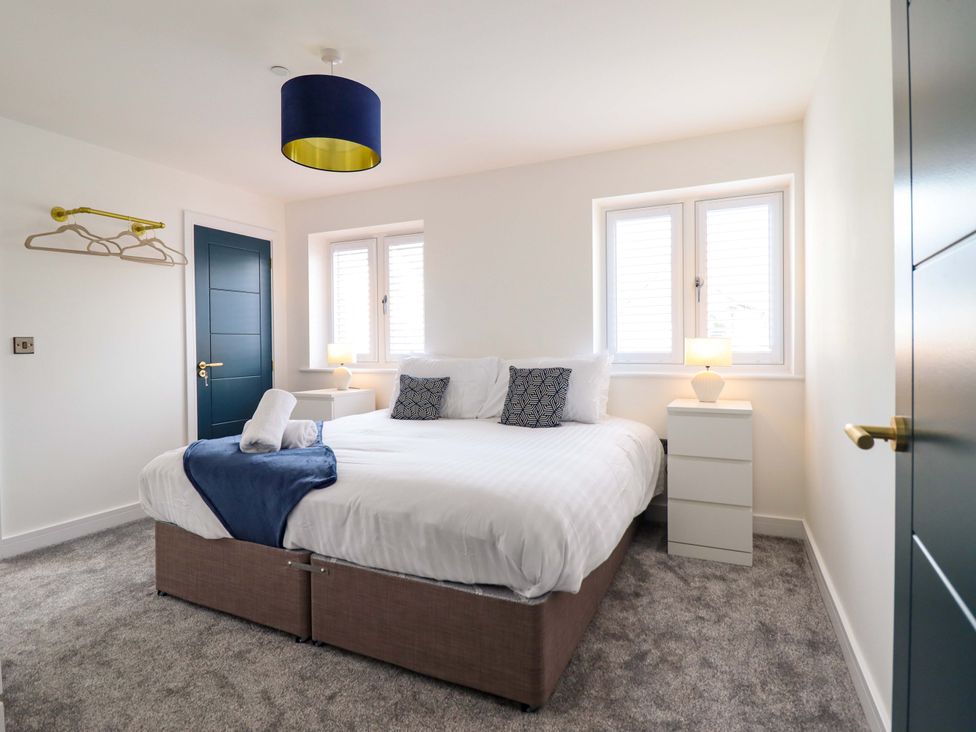 A bedroom with a bed and nightstand at Kingfisher 