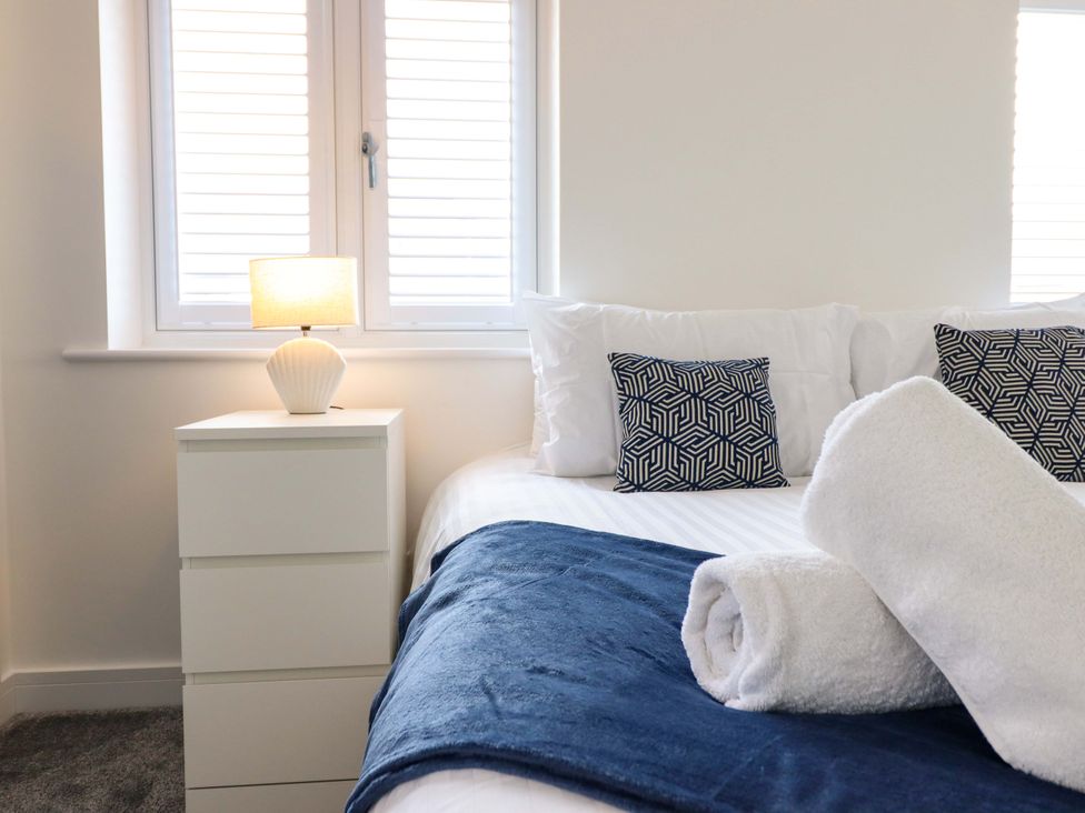 A bedroom with a bed and bedside table at Kingfisher