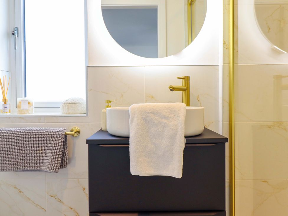 A bathroom with a sink and mirror at Kingfisher
