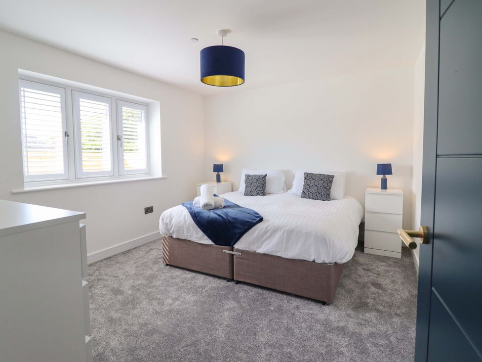 A bedroom with a bed and nightstands at Kingfisher