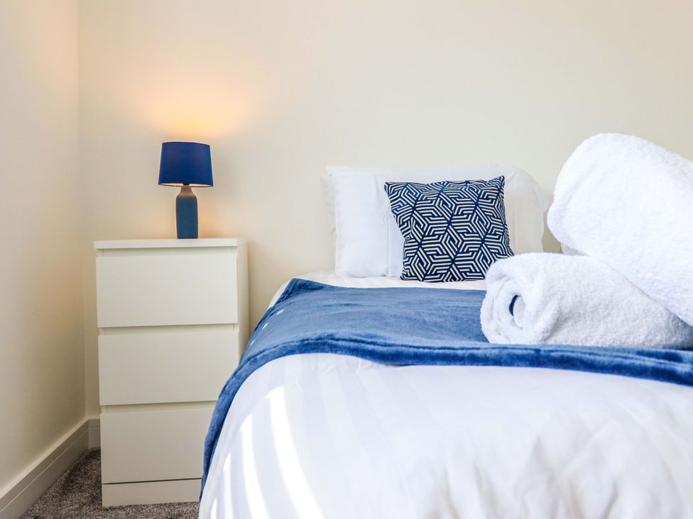 A bedroom with a bed and nightstand at Kingfisher