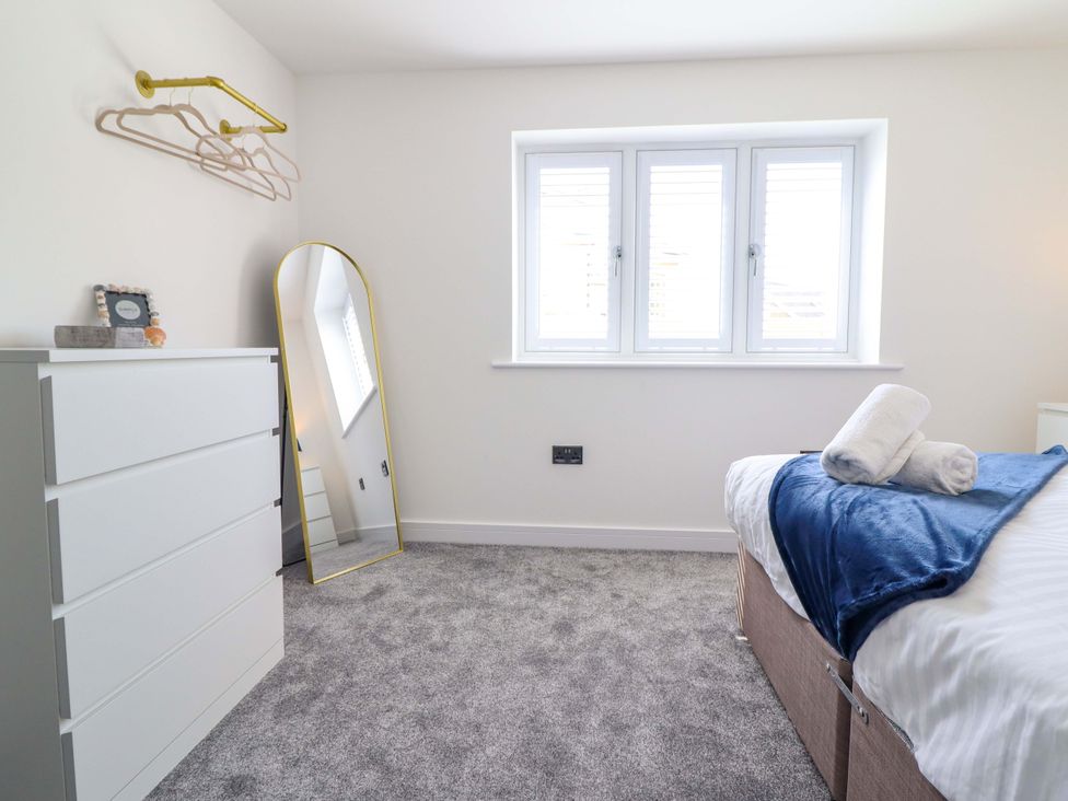 A bedroom with a bed and a mirror at Kingfisher