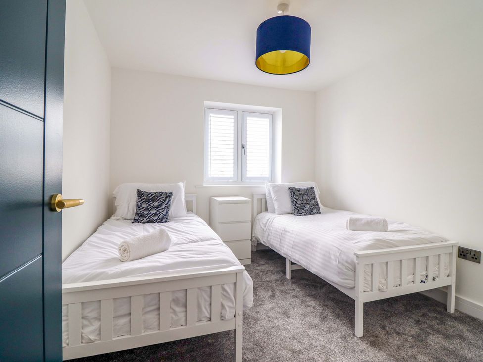 A bedroom with two beds and window at Kingfisher