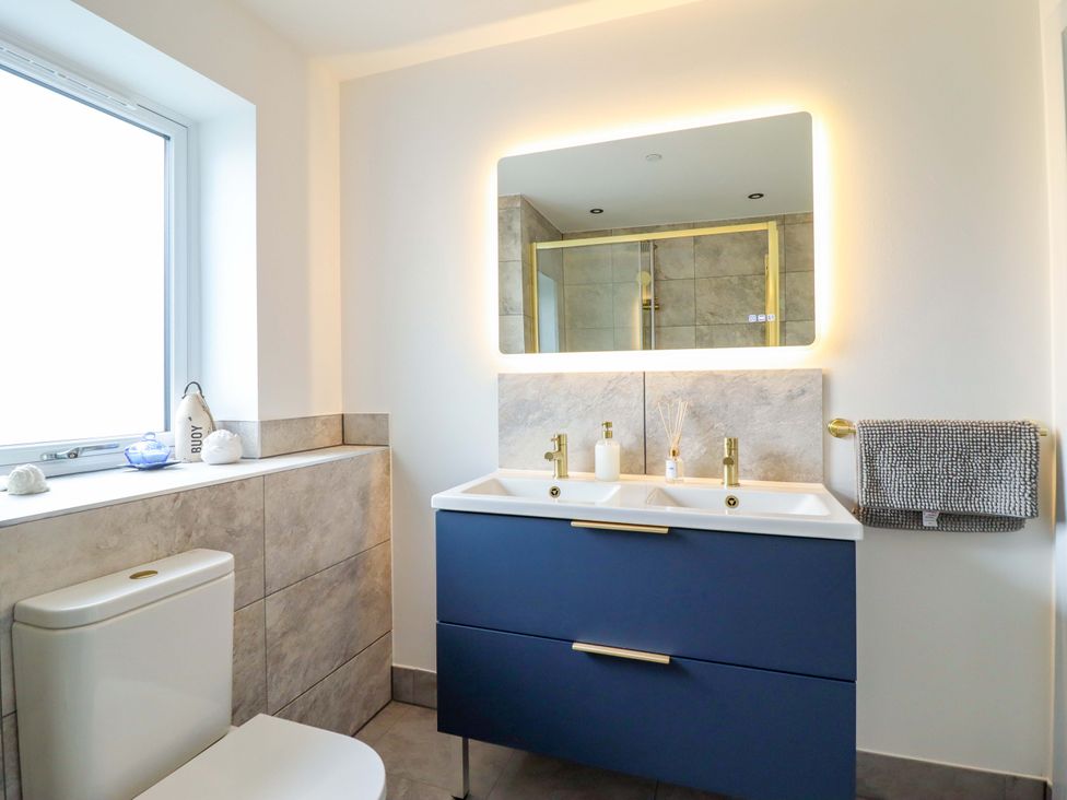 A bathroom with a vanity sink and a toilet at Kingfisher