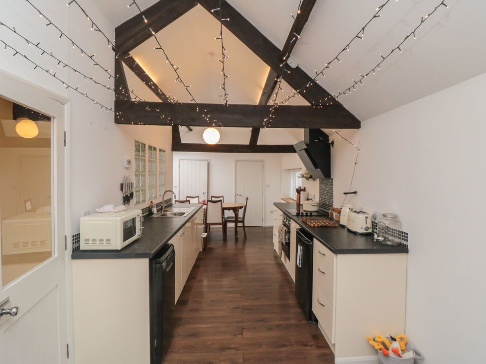 A kitchen with appliances including a stove, microwave, and table at The Joinery in Scarborough
