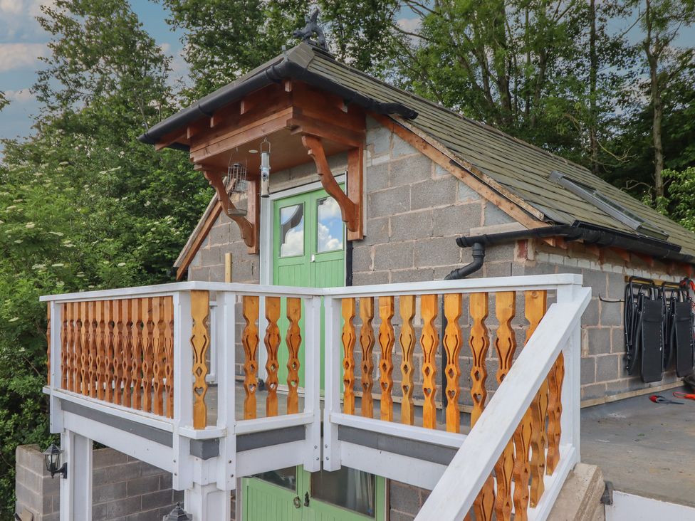 A balcony with a green door and slate roof at Hay Loft at Ebenezer Chapel Milwr