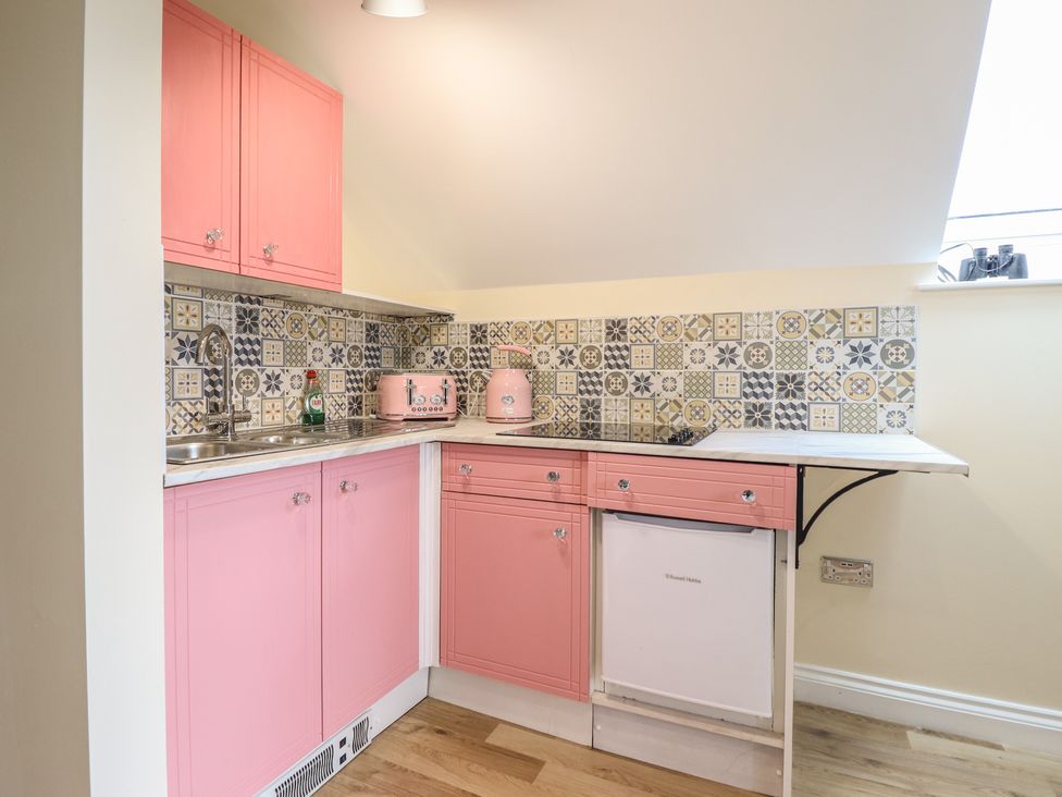 A kitchen with pink cabinets and appliances at Hay Loft at Ebenezer Chapel in Milwr