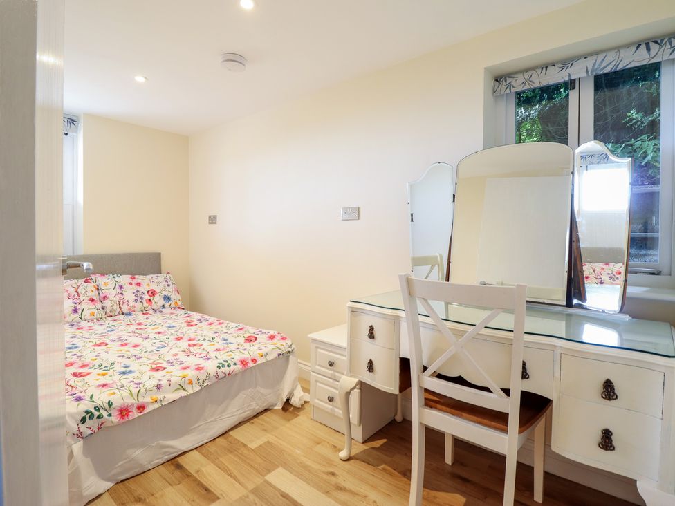 A bedroom with a bed and a dresser at Hay Loft at Ebenezer Chapel Milwr