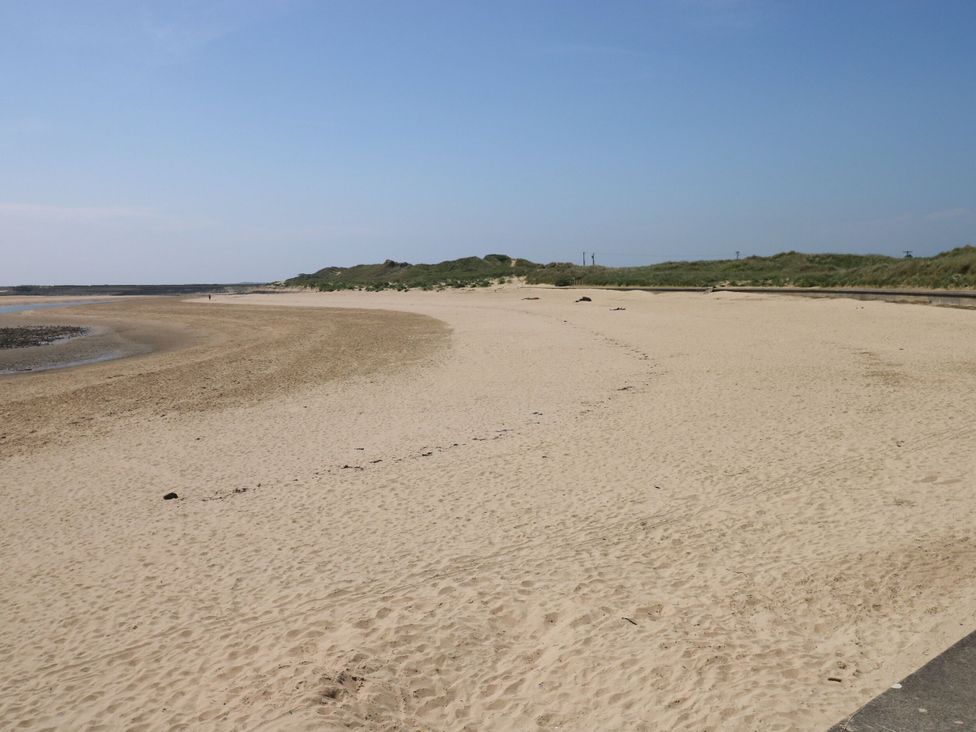 A beach with sand and water at Twyni Bach