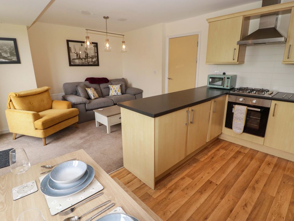 A kitchen and living area with furniture at Twyni Bach