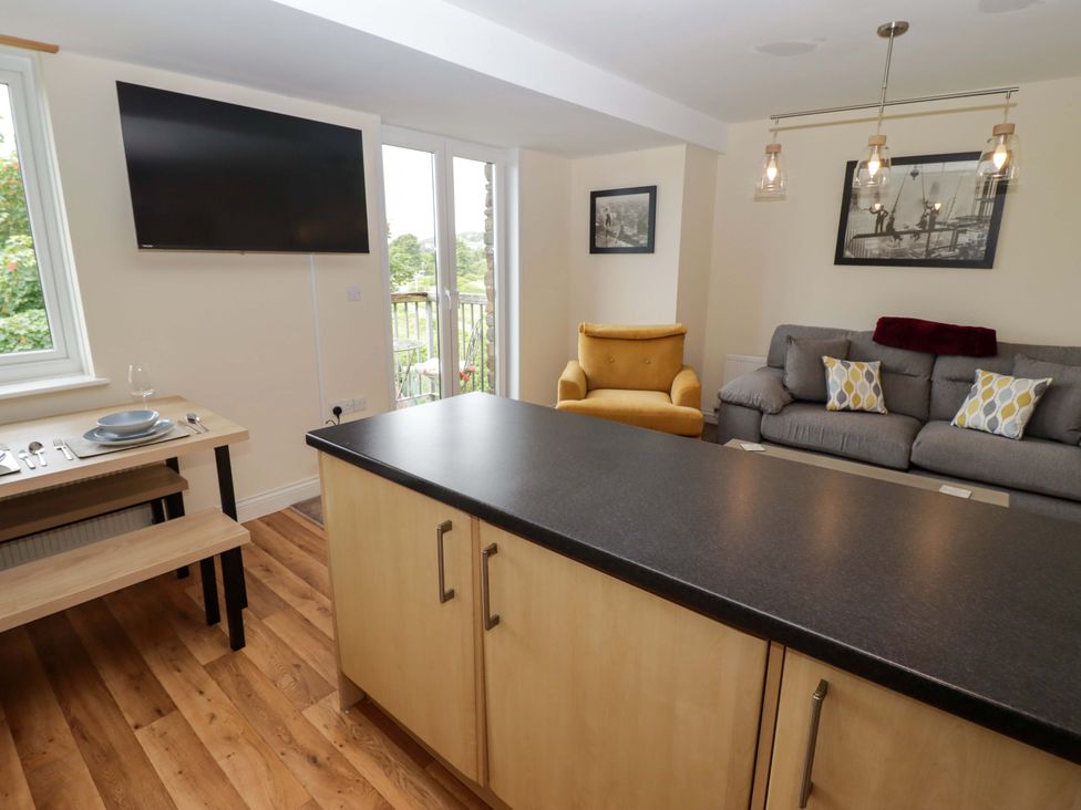 A living room with a television and dining table at Twyni Bach