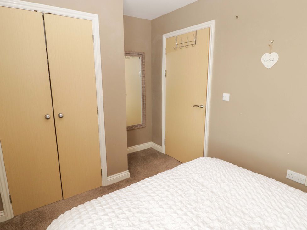 A bedroom with a wardrobe and mirror at Twyni Bach in 