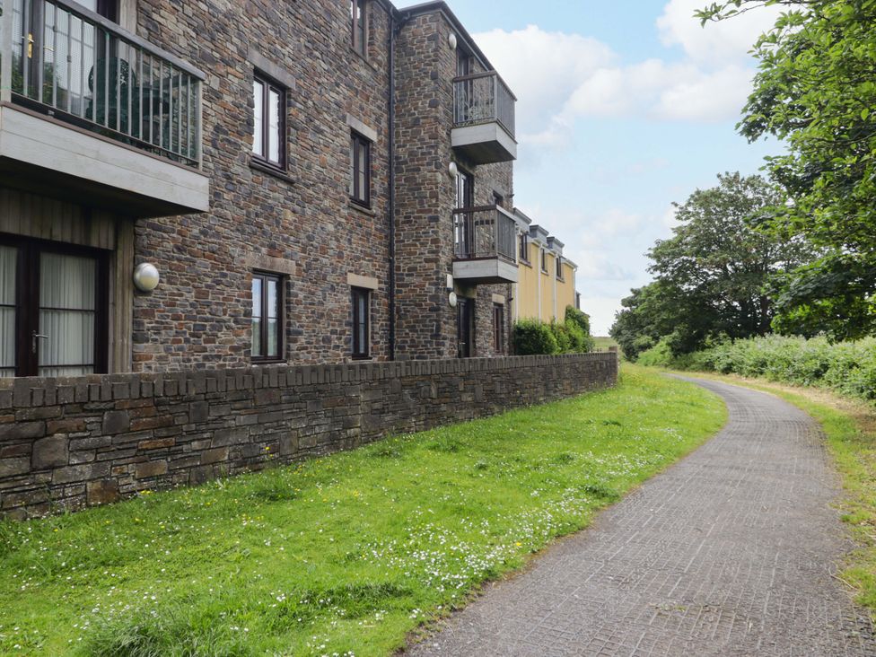 An outdoor view of a stone building with balconies and a pathway at Twyni Bach 