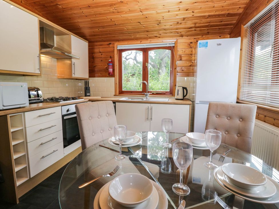 A kitchen with a table set for dining at 89 Ambleside White Cross Bay