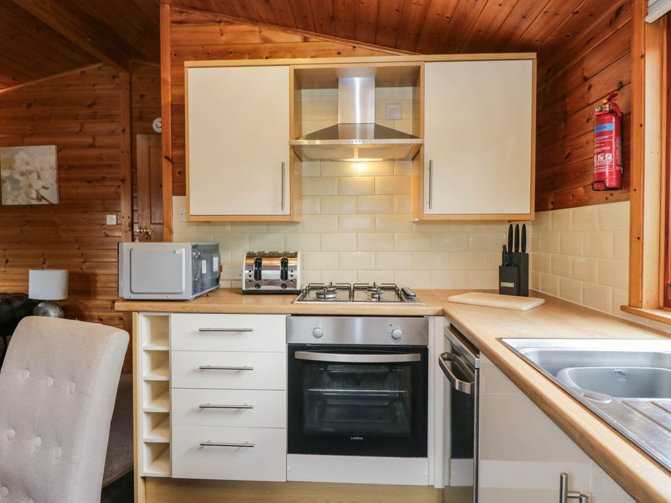 A kitchen with appliances and cabinets at 89 Ambleside White Cross Bay