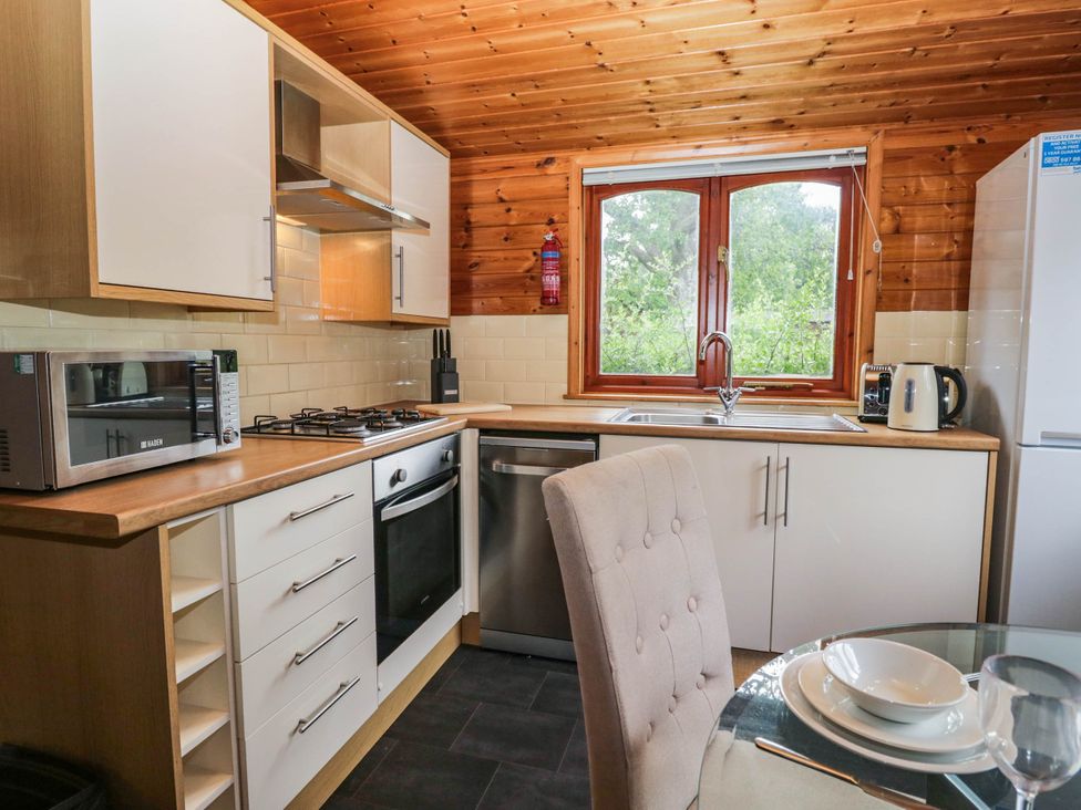 A kitchen with appliances including a microwave and kettle at 89 Ambleside White Cross Bay