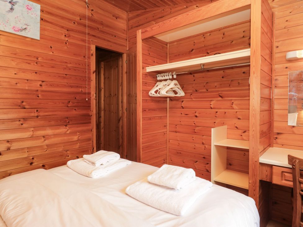 A bedroom with a bed and shelves at 89 Ambleside in White Cross Bay