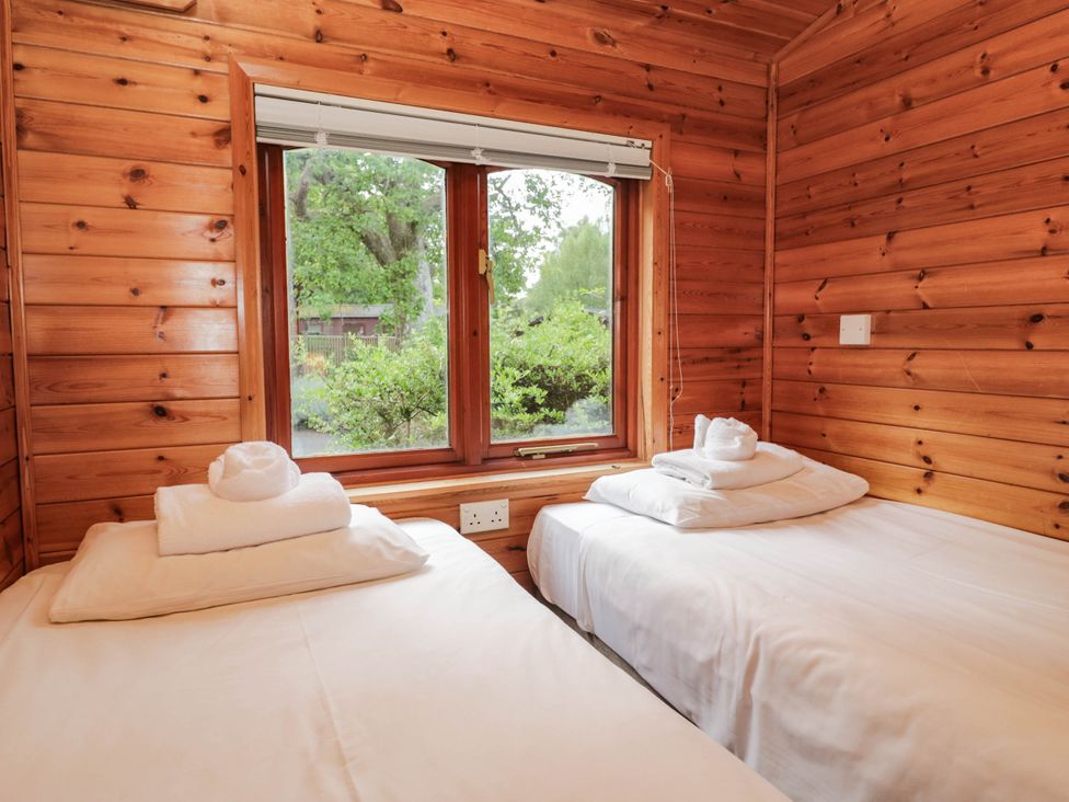 A bedroom with two beds and a window at 89 Ambleside in White Cross Bay