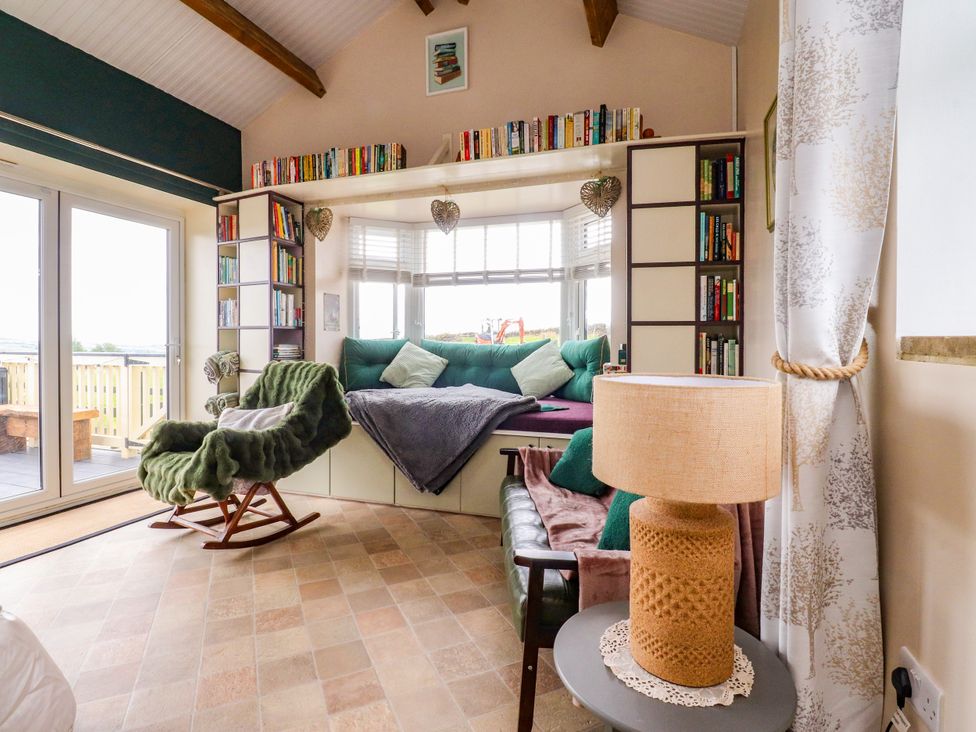 A snug with a bookshelf and seating area at The View in Ilkley