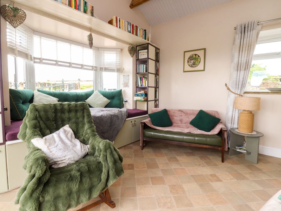 A snug with a bookshelf and seating at The View in Ilkley