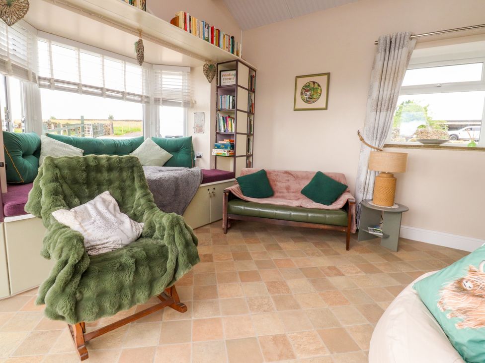 A snug with a green chair and a sofa at The View in Ilkley