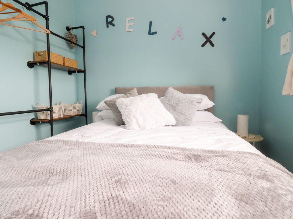 A bedroom with a bed and shelves at The View in Ilkley