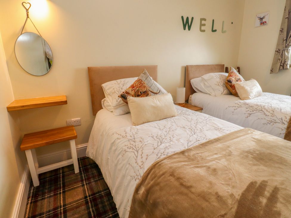 A bedroom with two beds and a mirror at The View in Ilkley