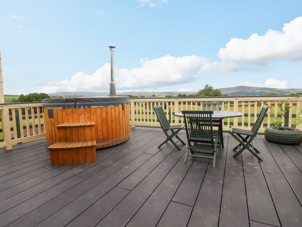 An outdoor space with a hot tub and dining set at The View in Ilkley