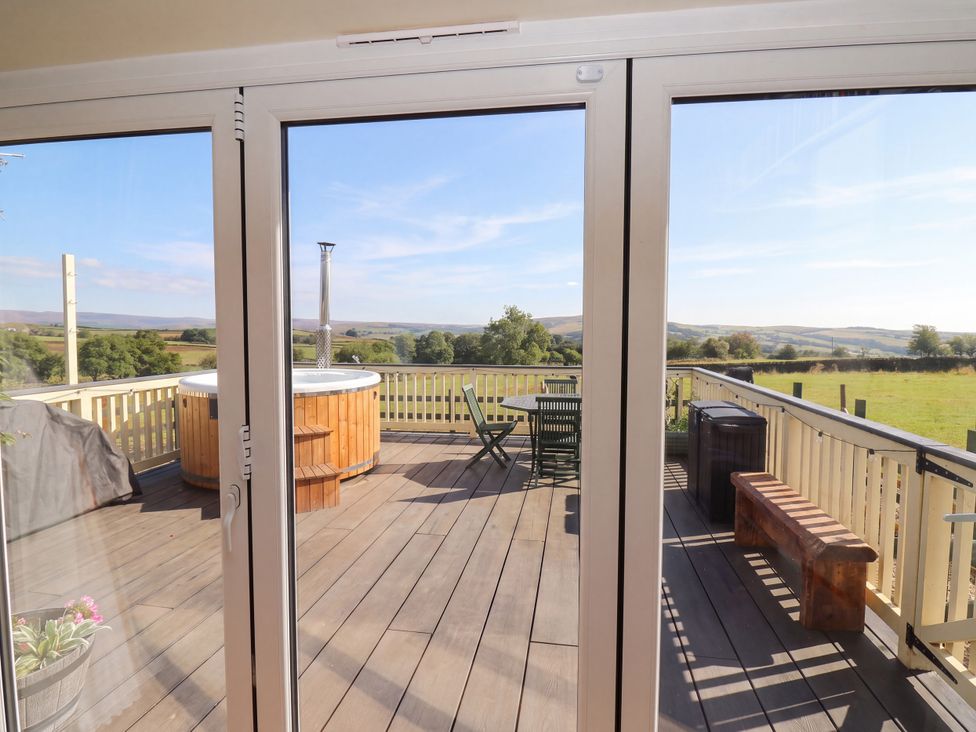 An outdoor deck area with a hot tub and seating at The View near Addingham