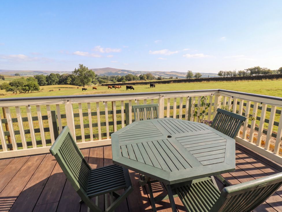 A deck area with a table and chairs overlooking fields at The View near Addingham