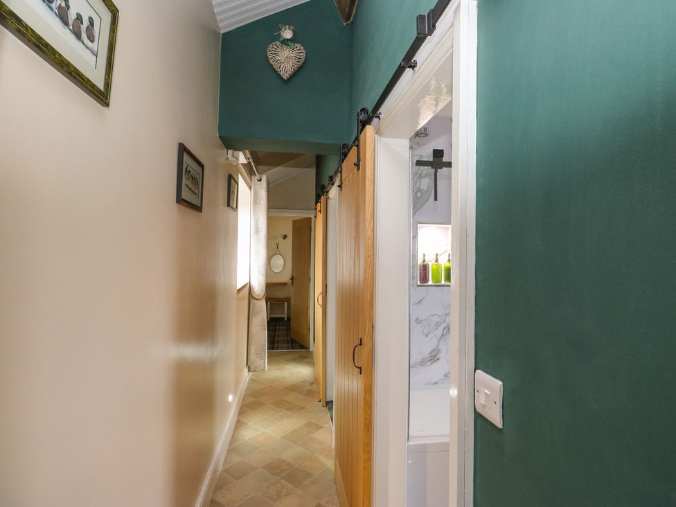 A hallway with wooden doors and a mirror at The View near Addingham