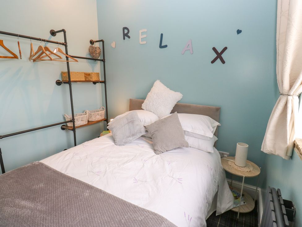 A bedroom with a bed and shelving units at The View near Addingham